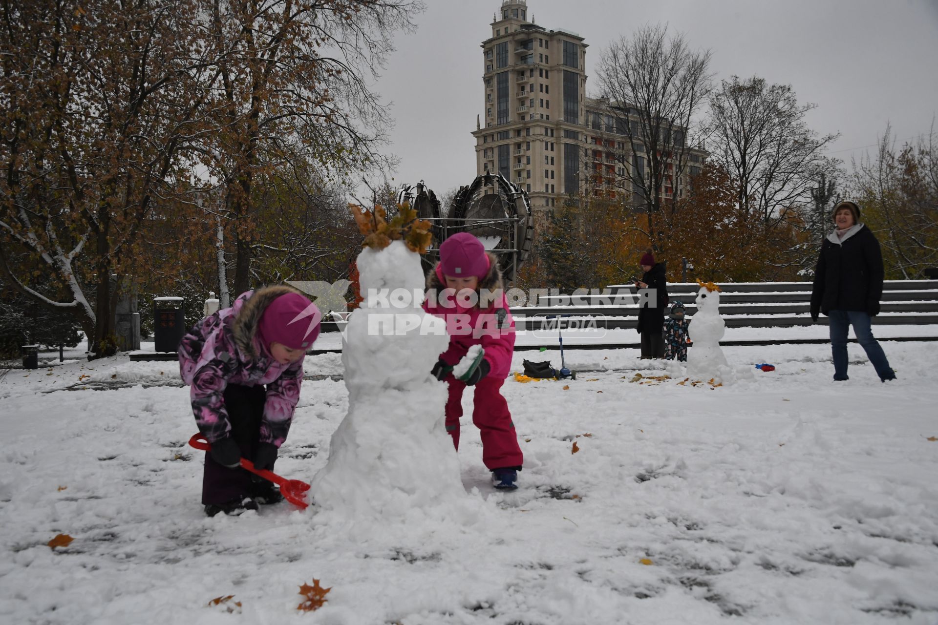 Москва.  Дети лепят снеговика в парке `Музеон`.