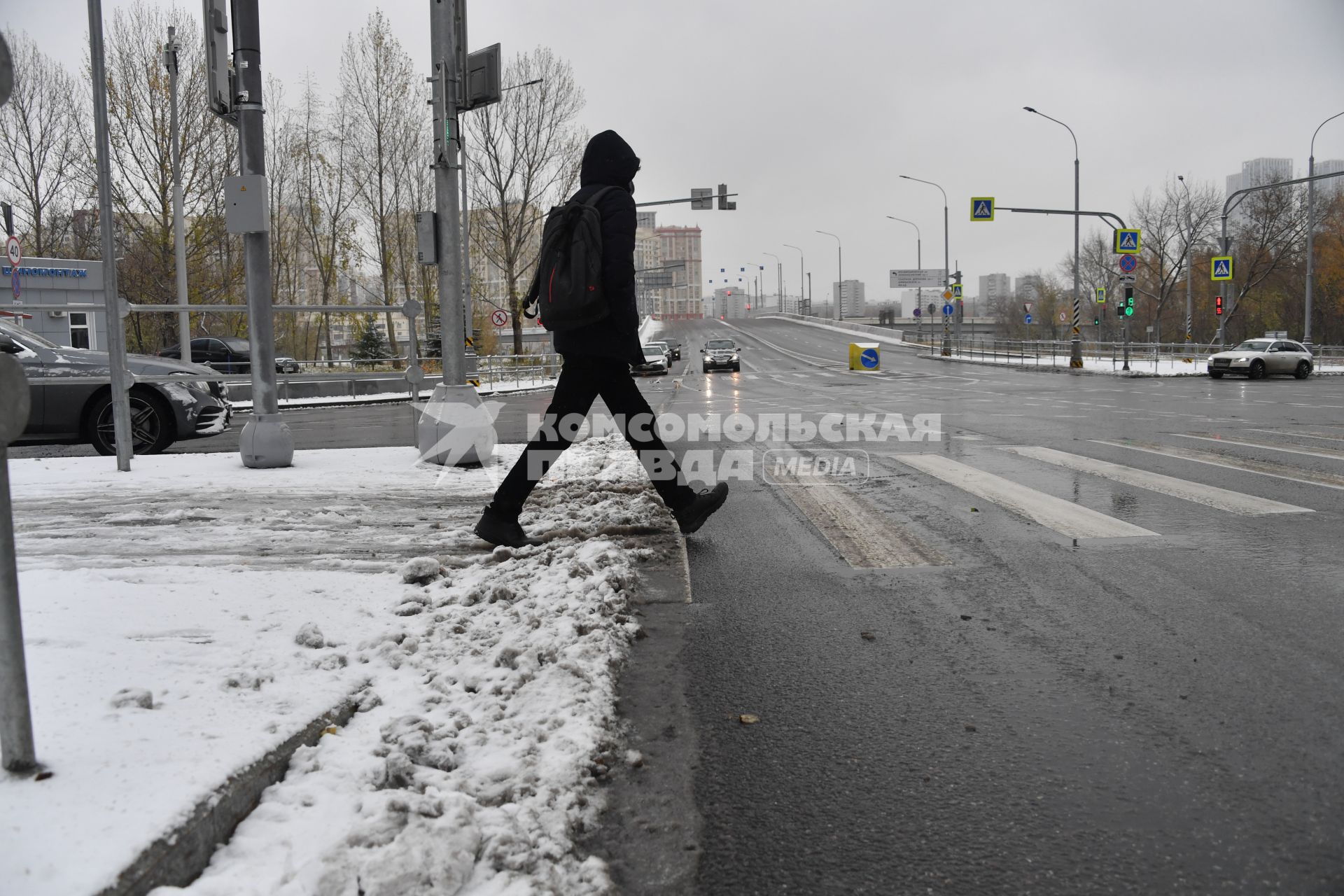 Москва. Мужчина переходит дорогу по пешеходному переходу.