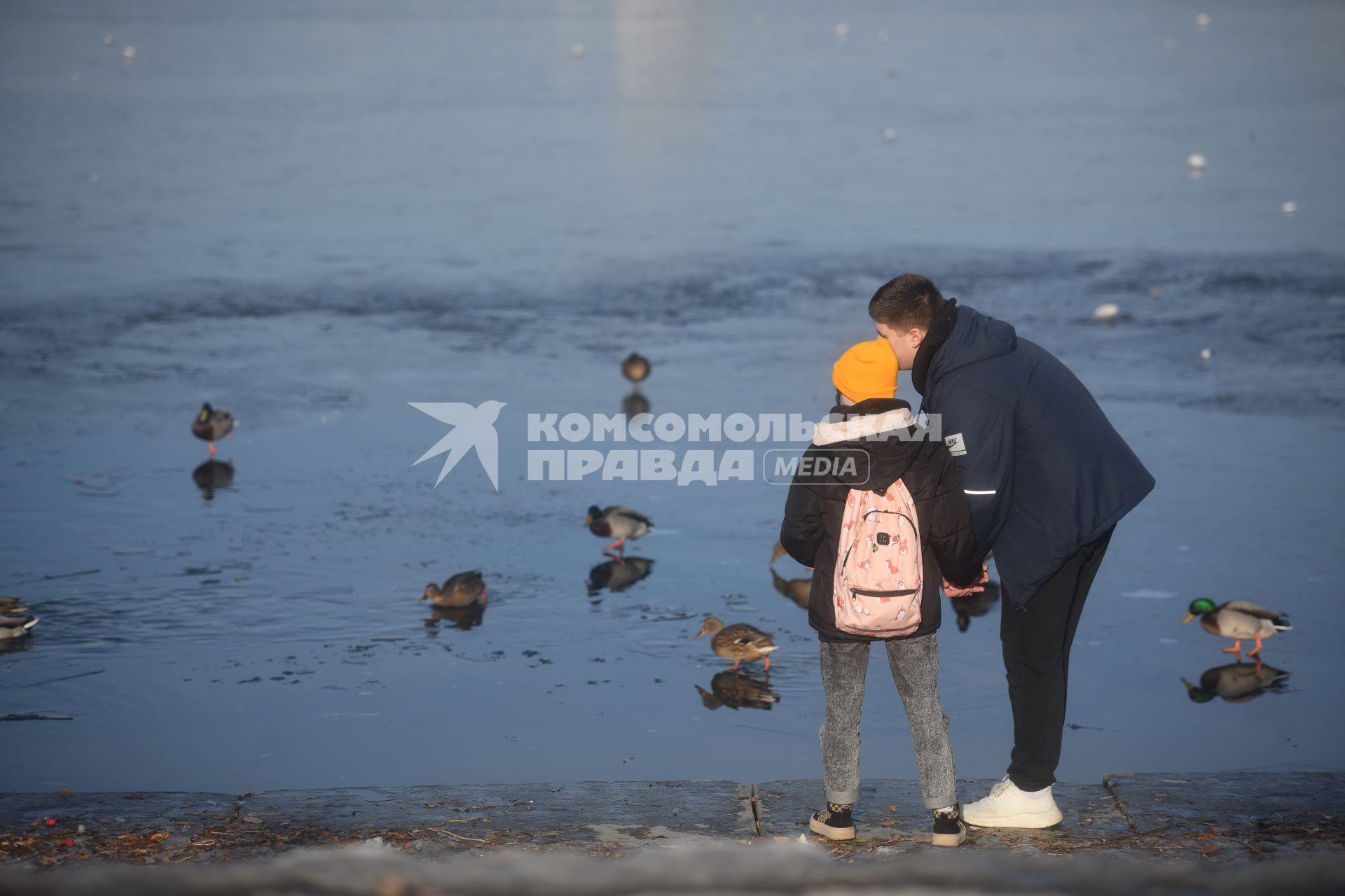 Екатеринбург. Парень с девушкой кормят уток на городском пруду