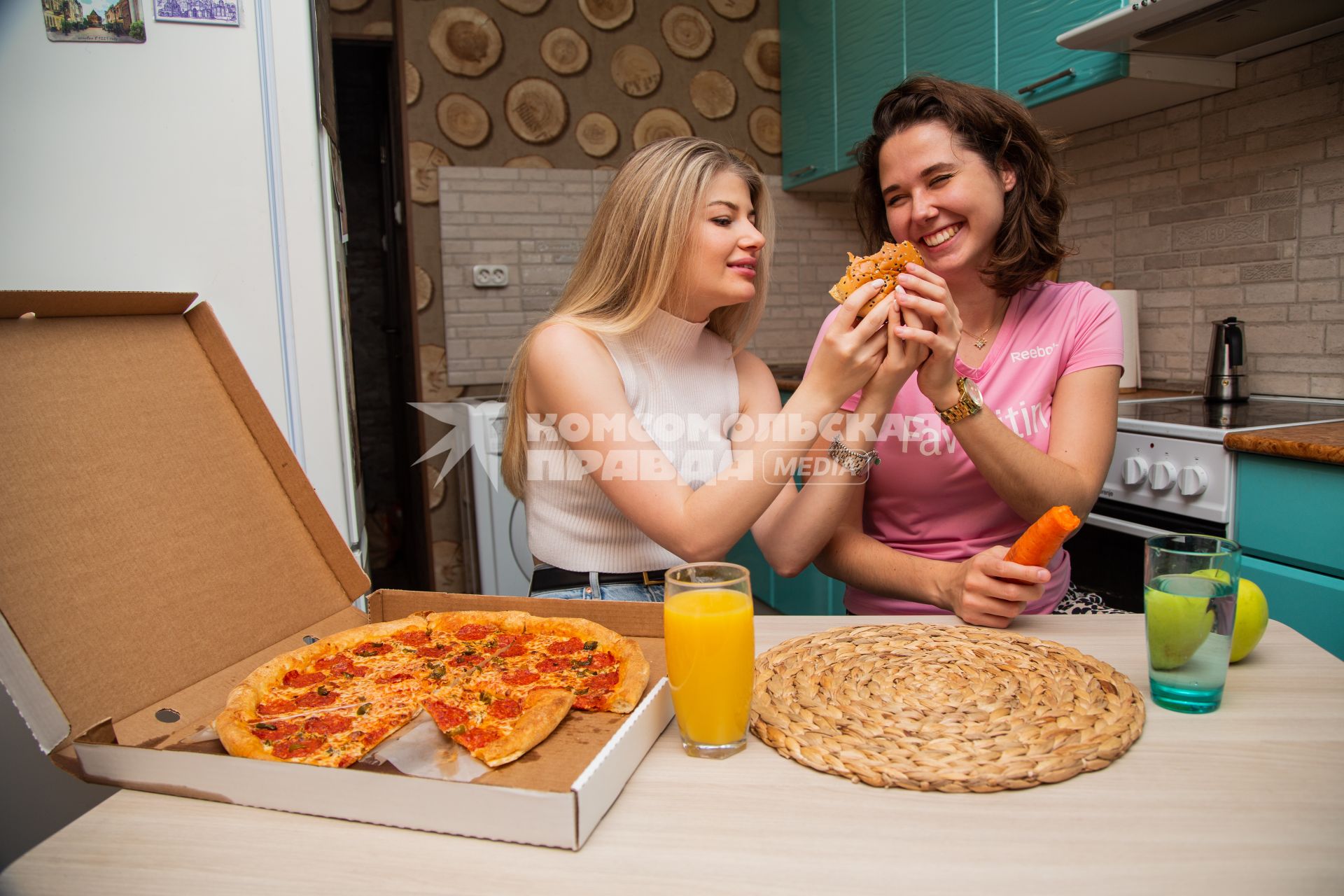 Москва.  Девушки дома едят пиццу и свежие овощи.