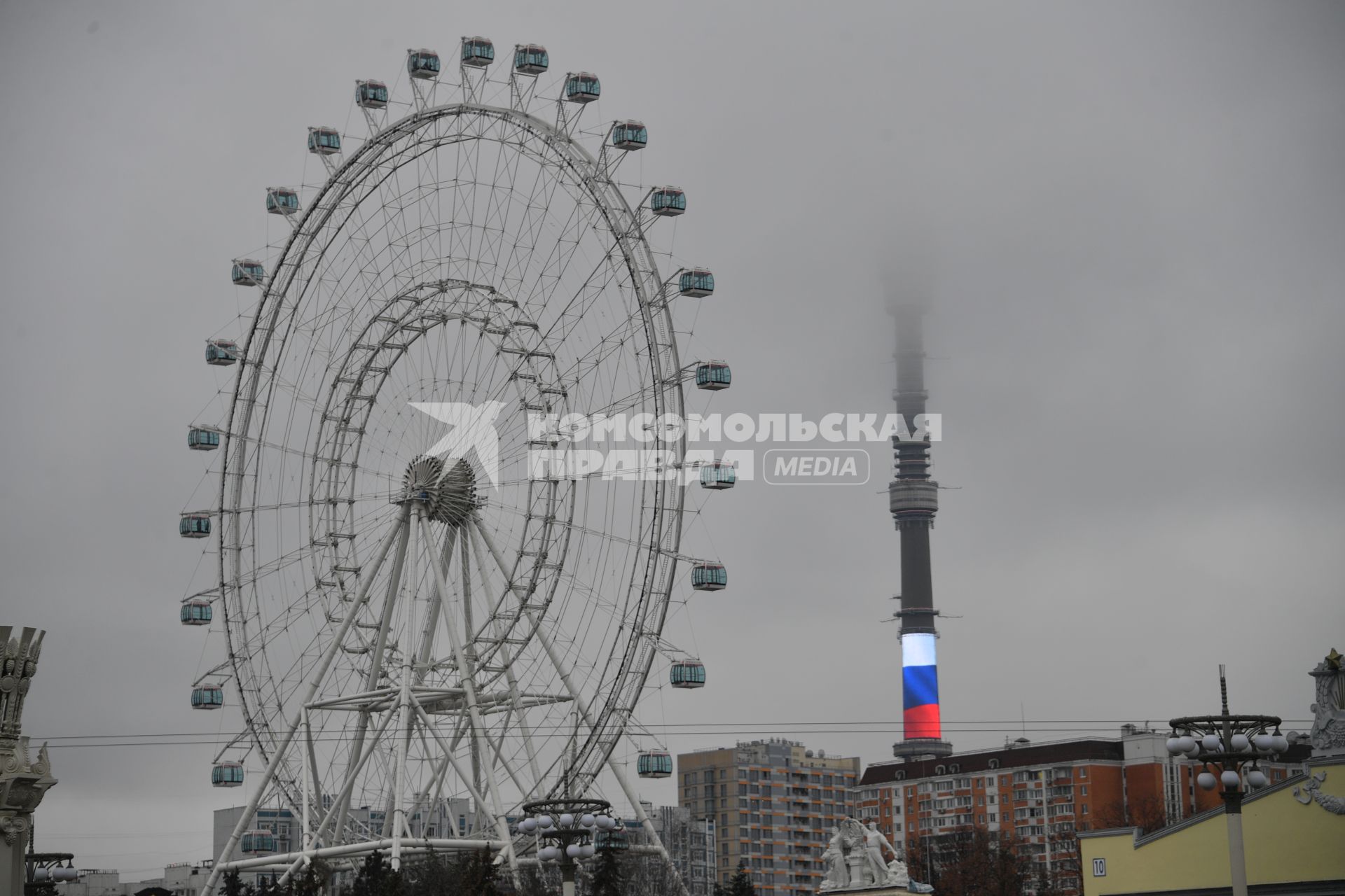 Москва.   Колесо обозрения `Солнце Москвы` и Останкинская башня в тумане.