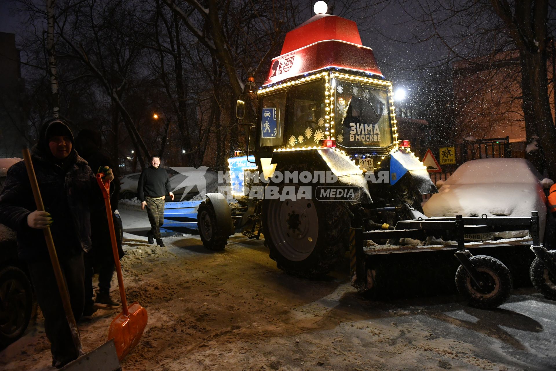 Трактор с новогодним дзайном убирает снег