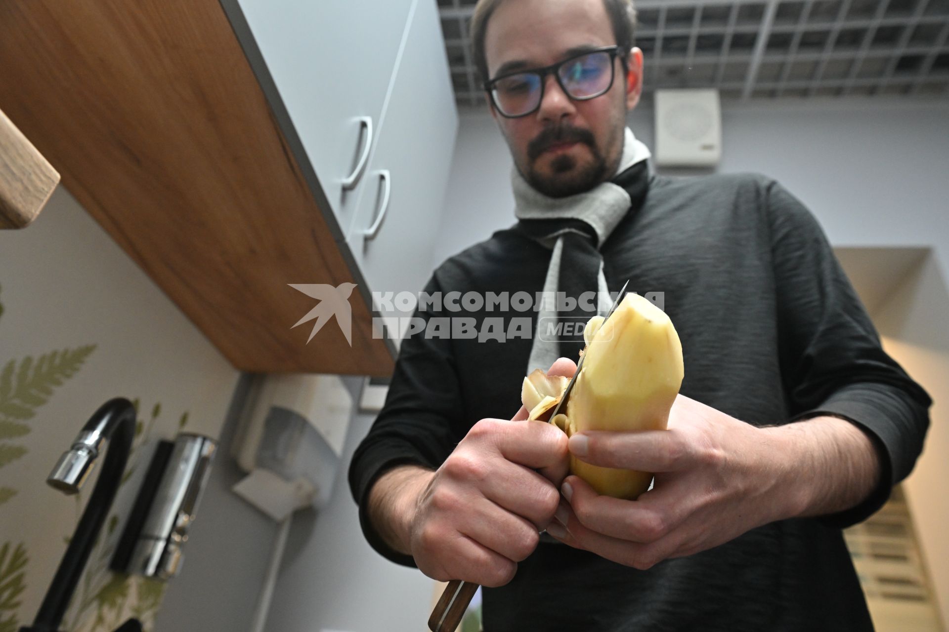 Мужчина чистит картошку