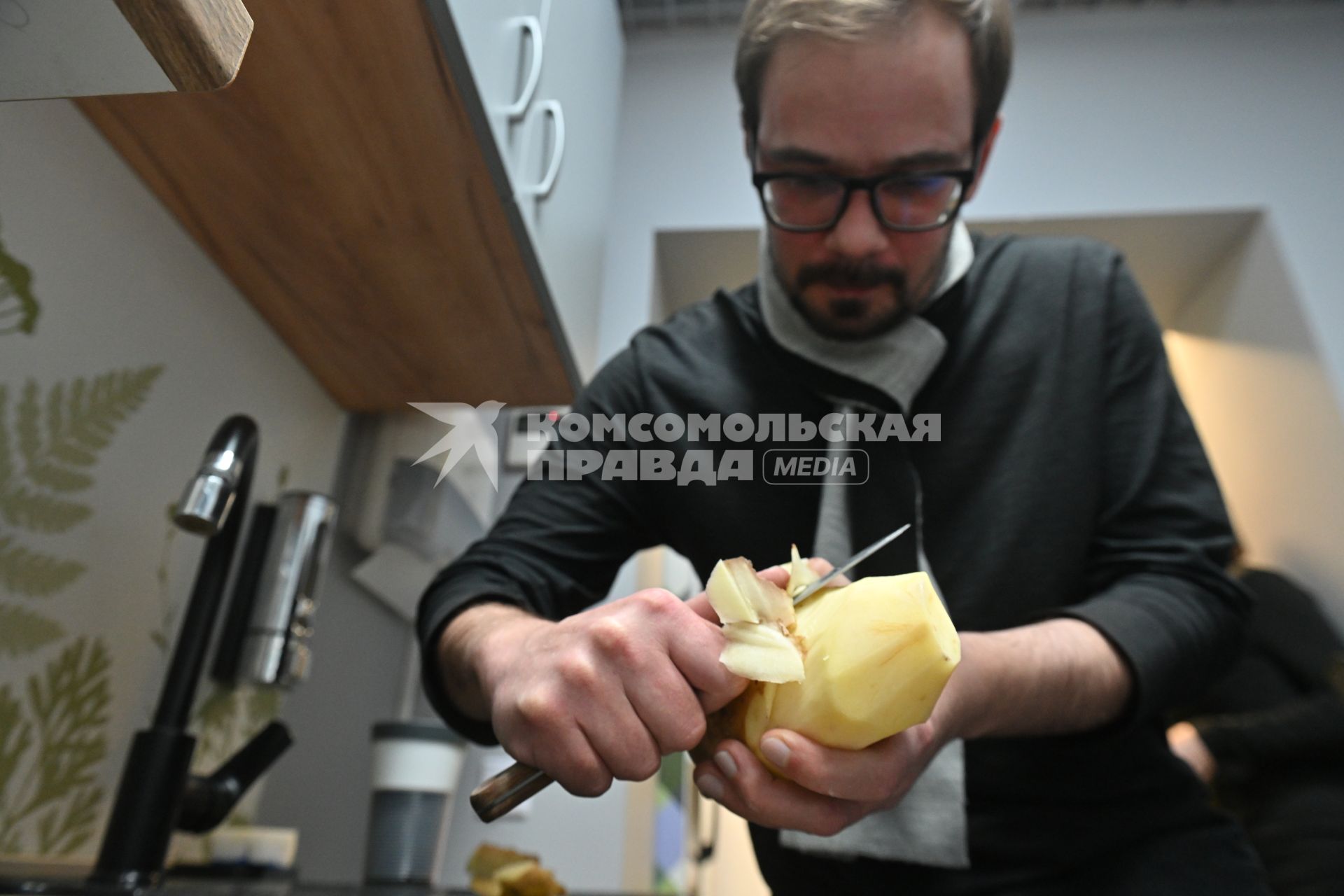 Мужчина чистит картошку